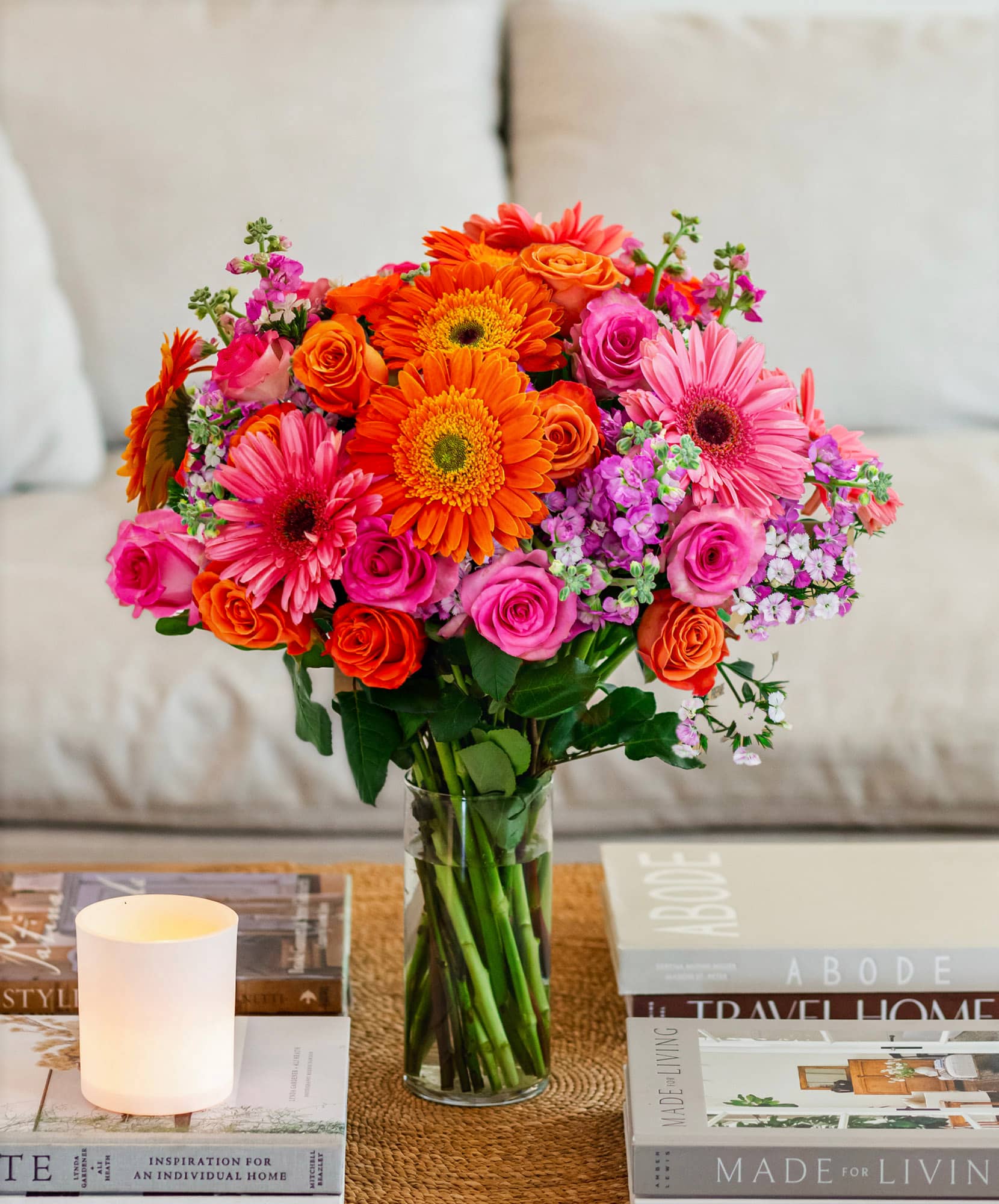 Vibrant floral arrangement featuring orange gerberas, pink roses, and cheerful blooms in a vase.