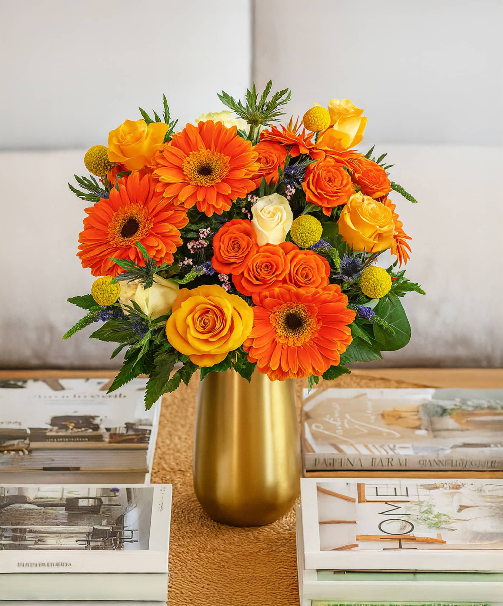 Vibrant floral arrangement featuring orange gerberas and yellow roses in a stylish vase.